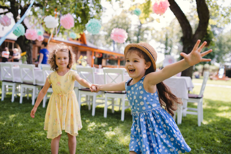 Two children play at a birthday party that is being managed and setup through an event planning agency.