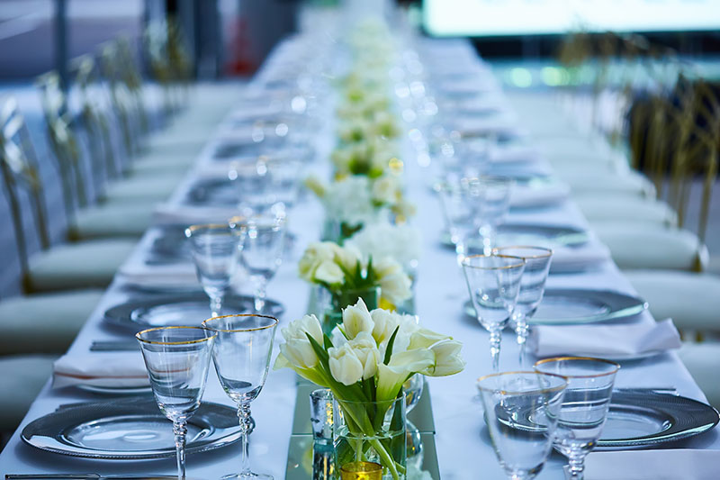 Dinner party floral arrangements line the middle of a dinner table.
